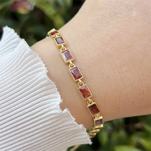 Detail von 18 Karat vergoldetem Armband mit roten Zirkonsteinen und Milgrain-Struktur