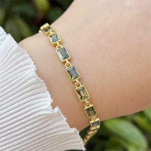 Detailansicht des 18k vergoldeten Armbands mit rechteckigen grünen Zirkoniasteinen