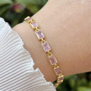 Detail eines 18k vergoldeten Armbands mit rosa Zirkonia-Rechtecken am Handgelenk