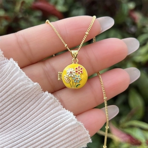 Foto de estilo de vida de collar relicario floral en esmalte amarillo bañado en oro de 18 quilates