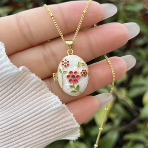 Collana a medaglione ovale placcata oro 18K con smalto bianco e motivi floreali a mano