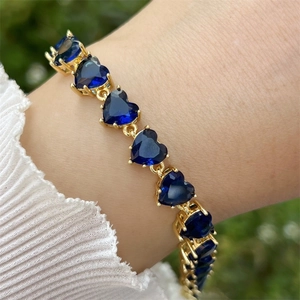 Detailansicht eines Herz-Armbands mit dunkelblauen Edelsteinen und 18K Goldbeschichtung