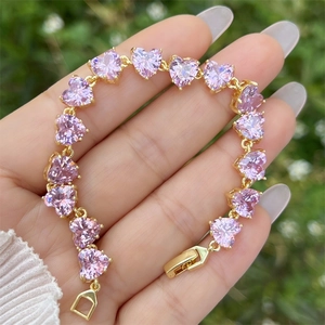 Detaillierte Nahaufnahme eines vergoldeten Armbands mit herzförmigen rosa Zirkonia