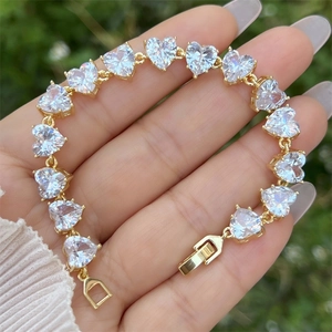 Detail eines vergoldeten Armbands mit funkelnden Herz-Zirkonia-Steinen und sicherem Verschluss