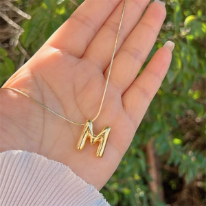 Polished 18K gold plated balloon letter M pendant on a sleek snake chain necklace