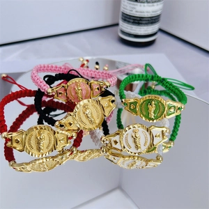Detail of hand-woven colorful religious bracelets with gold plated virgin mary medals