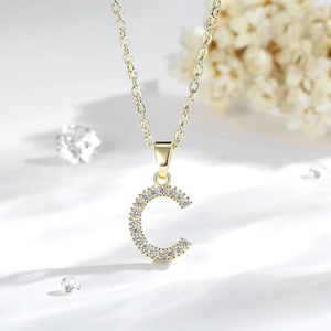 Dettaglio macro del ciondolo lettera C placcato oro 14K con zirconi cubici scintillanti