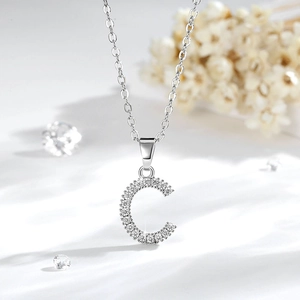 Dettaglio della collana con lettera C argentata decorata con brillanti zirconi cubici