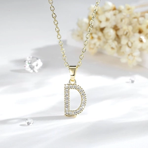 Macro del ciondolo a lettera D placcato oro 14K con pavé di cristalli scintillanti