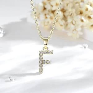 Dettaglio del ciondolo lettera F placcato oro 14K con pietre di zirconia incastonate