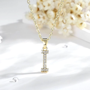Macro del ciondolo lettera I placcato oro 14K con zirconi scintillanti su sfondo bianco