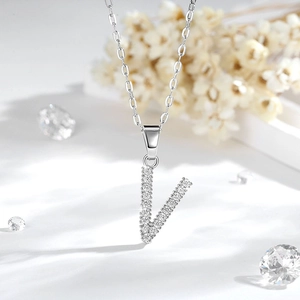 Dettaglio della collana con ciondolo lettera V in argento, zirconi e decoro floreale