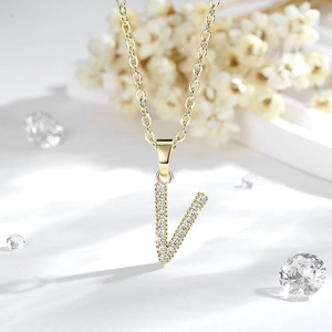 Macro del ciondolo a lettera V placcato in oro con zirconi brillanti a micro-pavé
