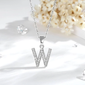 Dettaglio macro del ciondolo lettera W argento con pavé di cristalli di zirconia cubica