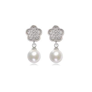 Macro detail of silver floral earrings featuring pavé cubic zirconia and white pearls