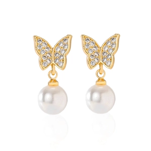 Macro view of gold butterfly earrings with cubic zirconia and a hanging round pearl