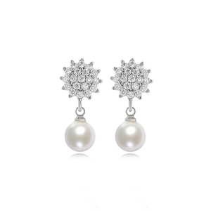 Detailed macro view of heart-shaped pearl earrings with cubic zirconia micro-pave