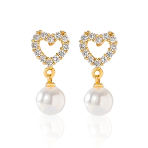 Detailed macro view of heart-shaped gold earrings with white pearls and sparkling zircons