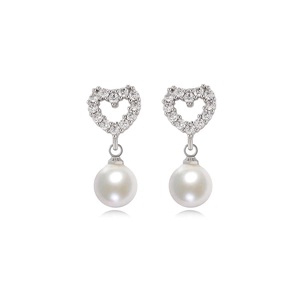 Close-up of heart-shaped gold plated earrings with zircon paving and dangling round pearls
