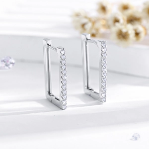 Detail of rectangular hoop earrings featuring a row of sparkling white zircons and silver finish