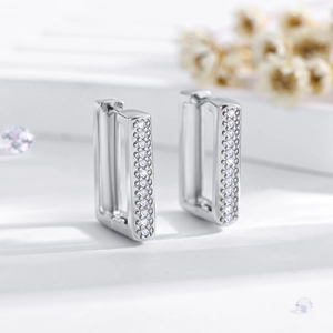 Macro shot of silver geometric rectangular hoop earrings with tiny white stones