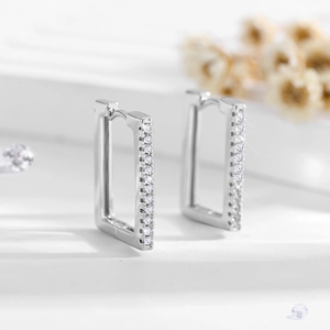 Macro shot of silver rectangular hoop earrings with pavé set white zircon stones