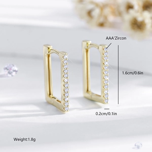 Macro shot of gold rectangle huggie earrings with AAA cubic zirconia inlays