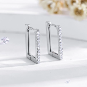Macro shot of silver rectangle huggie earrings featuring pavé-set round cubic zirconia