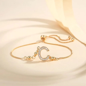 Detail of adjustable gold-plated bracelet with Zirconia inlaid letter C pendant and slider clasp