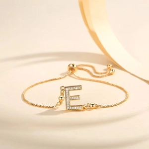 Macro view of gold-plated letter E bracelet featuring micro-pave cubic zirconia stones