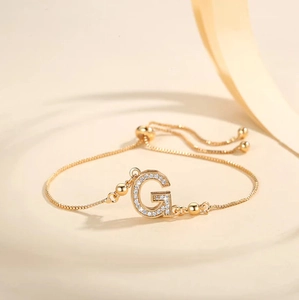 Detail of adjustable gold-plated box chain bracelet with cubic zirconia letter G pendant