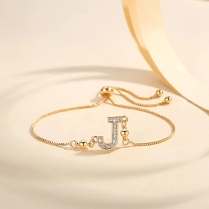 Detail of adjustable gold-plated bracelet with Zircon-inlaid letter J on a minimalist base