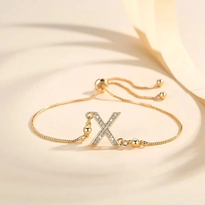 Detail of adjustable gold-plated bracelet with Zircon letter X and slider bead clasp