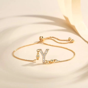 Macro shot of gold plated snake chain bracelet featuring zircon inlaid letter Y charm