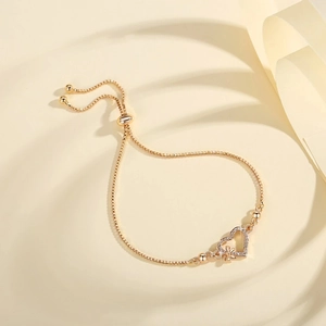 Adjustable gold heart bracelet with sparkling cubic zirconia and butterfly charm detail
