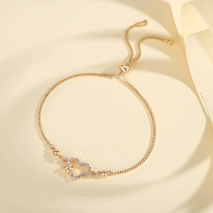Detail of adjustable gold heart bracelet with micro-pave crystals and bow accent