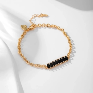 Detailed macro of gold plated bracelet with marquise cut black stones and tiny crystals