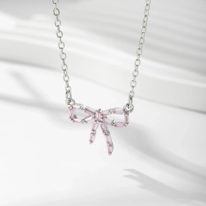 Détail macro du pendentif nœud argenté orné d'un zircon rose rectangulaire