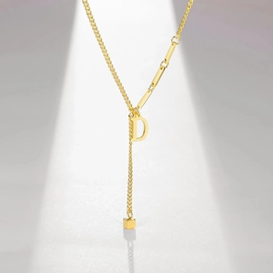 Detailed shot of gold-plated letter D pendant necklace with cubic tassel accent