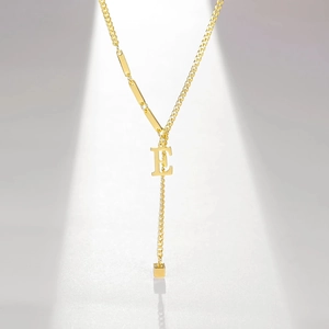 Detailed view of gold-plated letter E pendant necklace with modern asymmetrical chain design