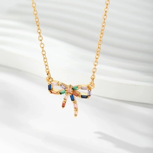 Gros plan du pendentif nœud avec zircons colorés sur chaîne fine plaquée or 18 carats