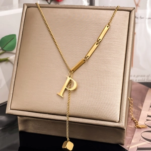Macro shot of gold-plated letter P pendant on Y-shaped chain with rectangle metal bars