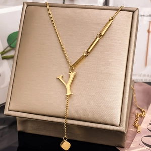 Detailed view of gold-plated letter Y pendant necklace on luxury display box