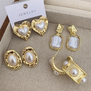 Set di orecchini a cuore e perla placcati in oro 18K su vassoio beige per gioielli