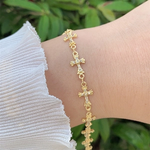 Elegant 18K gold plated copper cross bracelet with zircon accents on a female wrist