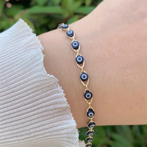 Close-up of 18K gold plated evil eye bracelet worn on wrist with blue beads