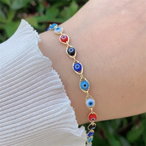 Detail of 18K gold-plated Evil Eye charm bracelet featuring colorful beads on a textured chain