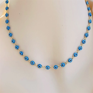 Close-up of 18K gold plated evil eye necklace with blue beaded accents on a mannequin