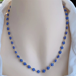 Detailed view of evil eye charms on an 18K gold plated copper chain necklace