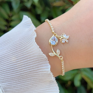 Dettaglio del bracciale a forma di tulipano e farfalla in oro 18K con zirconi colorati